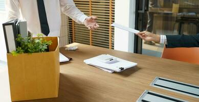 quitter emploi affaires homme Envoi en cours démission lettre et emballage des trucs démissionner déprimer ou porter affaires papier carton boîte dans bureau. changement de emploi ou mis à la porte de entreprise. photo