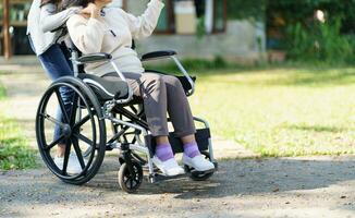 allaitement maison. Jeune soignant portion Sénior femme dans fauteuil roulant. photo