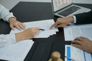 le conseiller juridique présente au client un contrat signé avec le marteau et la loi légale. concept de justice et d'avocat photo