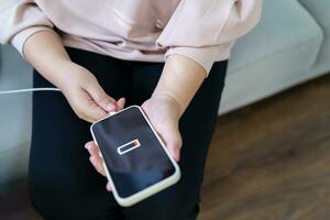 femme mains mise en charge mobile téléphone batterie avec faible batterie. bouchage une chargeur dans une intelligent téléphone avec énergie banque powerbank Puissance chargeur moderne mode de vie énergie La technologie concept photo