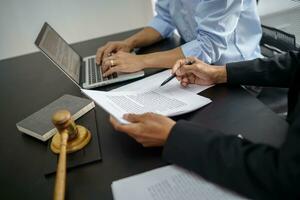 le conseiller juridique présente au client un contrat signé avec le marteau et la loi légale. concept de justice et d'avocat photo