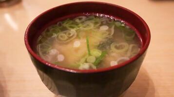 une bol de miso soupe, une Japonais classique. ouvré de dashi et miso pâte, il est une harmonieux mélange de les saveurs. prendre plaisir avec wakamé, Tofu, champignons, et plus pour un authentique goût de Japon. photo