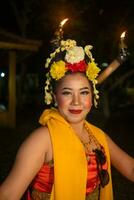 une traditionnel Javanais Danseur danses avec coloré fleurs sur sa poing tandis que sur étape photo