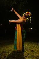 une traditionnel indonésien Danseur dansant avec le corps torsion sur étape photo