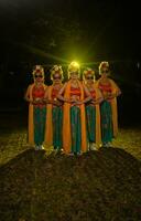 une groupe de indonésien traditionnel danseurs Danse avec leur copains dans de face de le étape lumières photo