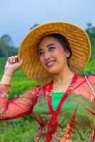 une thé feuille agriculteur en portant une bambou chapeau tandis que travail dans le thé jardin photo