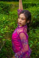 un asiatique femme posant très sexy parmi le thé plantations tandis que portant une rose robe photo