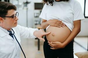 Enceinte africain femme a rendez-vous avec médecin à clinique. Masculin  gynécologue ob gynécologue médical spécialiste