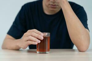 déprimé Jeune asiatique homme intoxiqué sentiment mal en buvant whisky seul à maison, stressé frustré solitaire en buvant de l'alcool souffre de problématique alcool, alcoolisme, la vie et famille problèmes photo