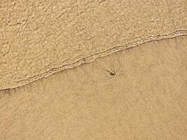 plage humide le sable texture. sablonneux rive beige Contexte. photo