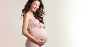 contenu Enceinte femme souriant et caressant ventre montrer du doigt à blanc Contexte profiter grossesse anticipant maternité photo