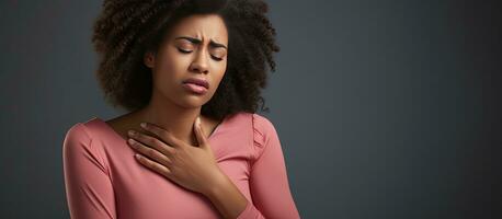 malheureux Jeune noir femme avec acide reflux isolé sur gris Contexte photo