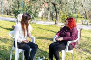 filles fumant une cigarette électronique dans le jardin photo