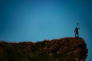 silhouette de homme sur Montagne Haut plus de ciel et Soleil lumière arrière-plan, entreprise, succès, direction, réussite et gens concept photo