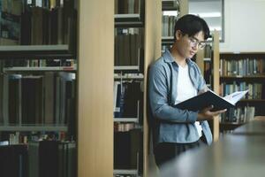 Université élèves en train de lire livres dans bibliothèque pour recherche. photo