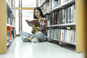 Université élèves en train de lire livres dans bibliothèque pour recherche. photo