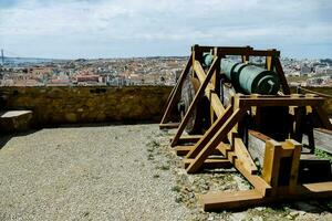 une canon sur Haut de une pierre mur surplombant une ville photo