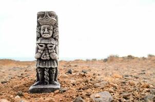 une statue de une homme permanent dans le milieu de une désert photo