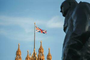 Célibataire syndicat jack drapeau agitant dans de face de gros ben à le Maisons de parlement dans Londres, Royaume-Uni sur une clair ensoleillé journée. winston Churchill statue. photo