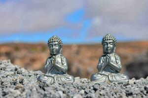 deux petit argent Bouddha statues séance sur Haut de rochers photo