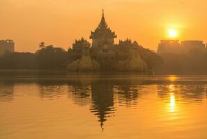 beau lever de soleil sur le palais de karaweik dans le canton de yangon au myanmar. photo
