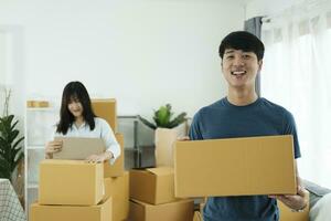 content Jeune couple avec papier carton des boites dans leur Nouveau maison. photo