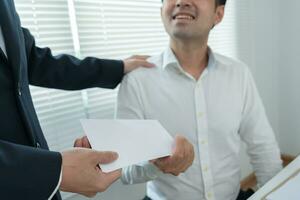 les hommes d'affaires reçoivent un salaire ou des primes de la direction ou du patron. l'entreprise donne des récompenses pour encourager le travail. homme d'affaires souriant bénéficiant d'une récompense au bureau du bureau. photo