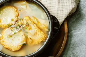 coréen poisson gâteau soupe servi dans une noir argile pot photo