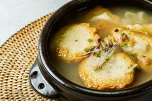 coréen poisson gâteau soupe servi dans une noir argile pot photo