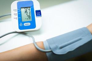 une femme médecin mesure la pression artérielle du patient souffrant d'hypertension à l'aide d'un appareil automatisé dans la clinique de l'hôpital. concept médical et de soins de santé photo