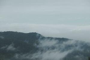 Montagne intervalle avec visible silhouettes par le Matin bleu brouillard. photo