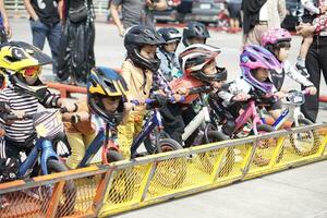 depok-indonésie, 29 07 2023 - indonésien des gamins de 2-5 ans vieux prêt à les courses sur équilibre bicyclette dans une parking zone, esprit sportif entraînement. photo