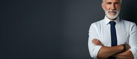 studio moitié portrait de une Sénior homme dans une chemise et attacher permanent avec bras franchi contre un isolé Contexte côté profil avec copie espace photo