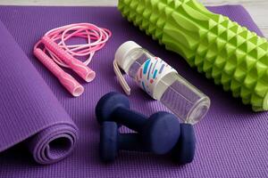 massage rouleau, haltères, l'eau bouteille et sauter corde sur une Gym tapis photo