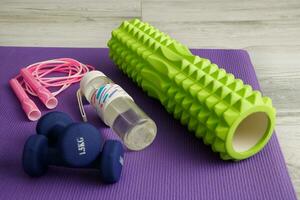 massage rouleau, haltères, l'eau bouteille et sauter corde sur une Gym tapis photo