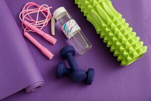 massage rouleau, haltères, l'eau bouteille et sauter corde sur une Gym tapis photo