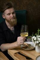 du vin dans une verre dans une homme main à une restaurant table photo