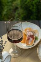 une verre de du vin sur une Contexte de gâteaux au fromage sur une table en plein air photo