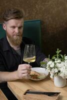 du vin dans une verre dans une homme main à une restaurant table photo