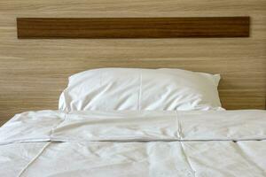 doux oreiller sur une confortable bois lit. chambre intérieur. de face vue photo