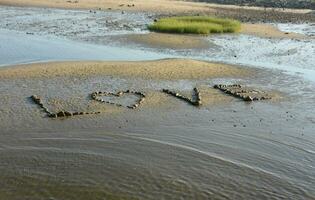 l'amour message orthographié en dehors sur une plage dans rochers photo