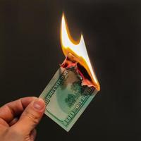 la main tient cent dollars brûlants. illustration de la crise financière et de la perte d'argent et de capital. photo
