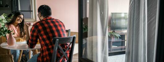 bannière Jeune diverse aimant couple en mangeant croissant et pourparlers ensemble à Accueil dans petit déjeuner temps copie espace. la communication et relation concept photo