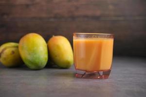 jus de mangue fraîche avec du lait dans un verre sur table photo