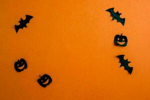 Halloween arrière-plan, papier noir chauves-souris et citrouilles sur un Orange Contexte. photo
