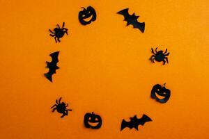 Halloween arrière-plan, papier noir chauves-souris, citrouilles et les araignées sur un Orange arrière-plan, Cadre. photo