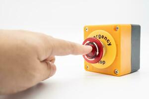 bouton d'arrêt et la main du travailleur sur le point d'appuyer dessus. bouton d'arrêt d'urgence. gros bouton d'urgence rouge ou bouton d'arrêt pour une pression manuelle. photo