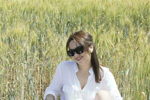 une femme dans une blanc robe permanent dans une champ photo