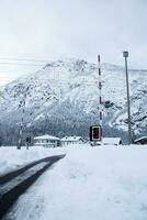 une neigeux route dans le montagnes avec Maisons photo