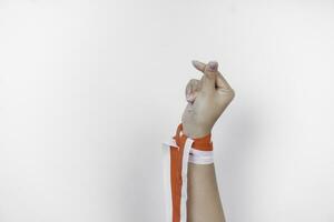 mains faire des gestes l'amour signe portant indonésien rouge et blanc ruban. l'indonésie indépendance journée concept photo